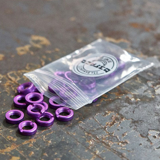 A transparent plastic bag with purple bananuts (3.5mm socket nuts) spilling out onto a metallic surface.