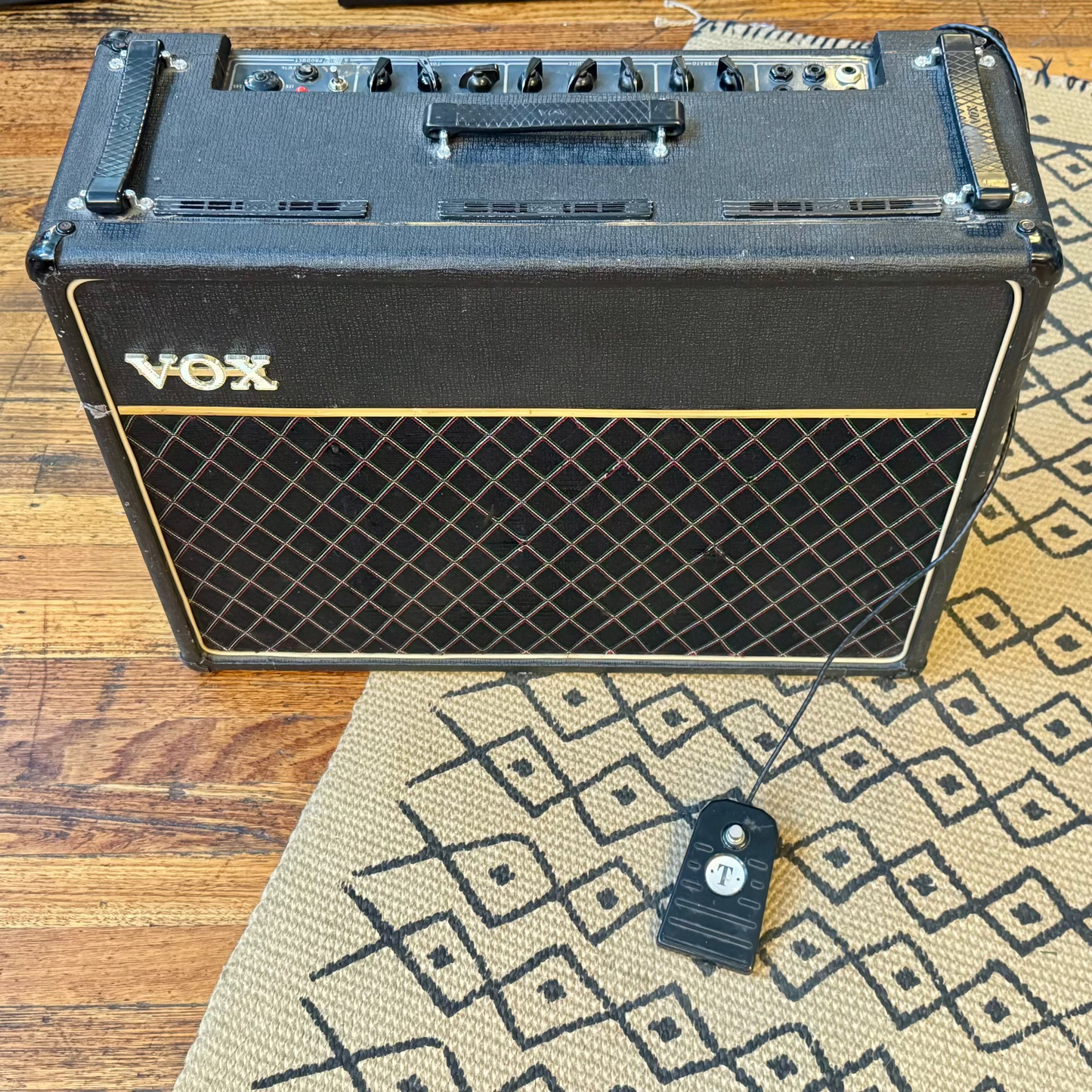 Vox amplifier on a wooden floor with a patterned rug