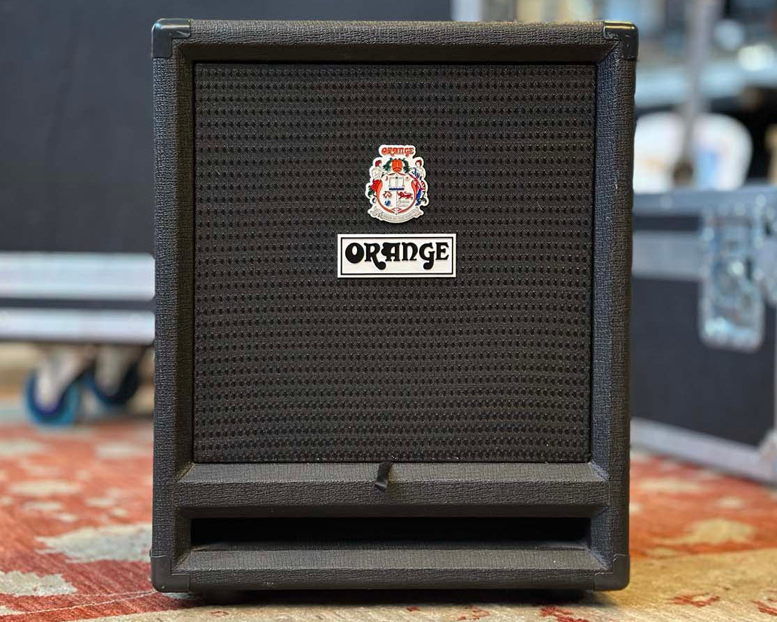 Black guitar amplifier with Orange logo on a patterned rug
