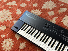 Load image into Gallery viewer, Keyboard on a floral-patterned red and beige rug
